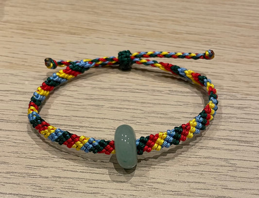 Handmade bracelet with colourful string and a jade ring