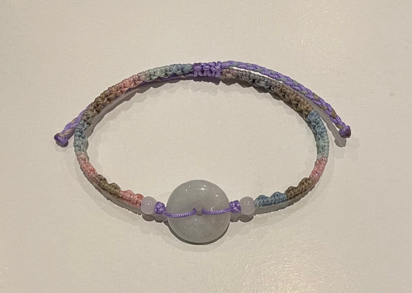 Handmade bracelet with light purple jade donut and gradient colour waxed string
